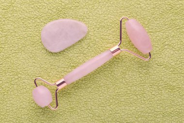 Gül kuvars yüz silindiri yeşil ve masaj taşı arka plan, düz yatıyordu