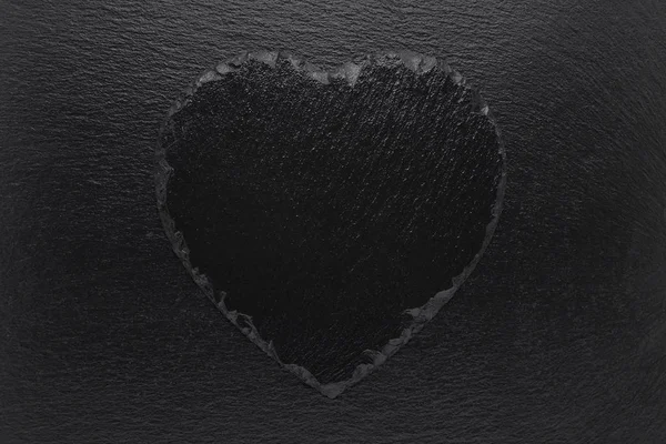 Black heart slate plate on black background