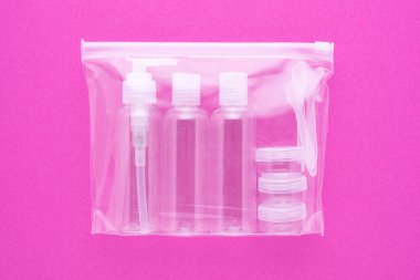 travel toiletries, small plastic bottles for hygiene products on pink background