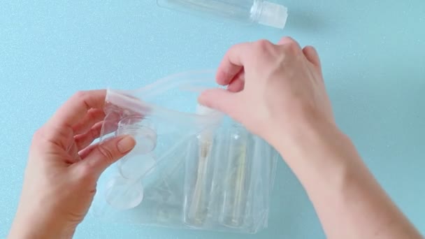 A woman takes plastic bottles from a bag — 图库视频影像