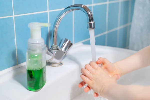 Ребенок моет руки жидким антибактериальным мылом — стоковое фото