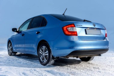 Vorkuta, Komi / Rusya - 12 01 2018: Kışın kar altında farları açık Skoda Rapid mavi araba