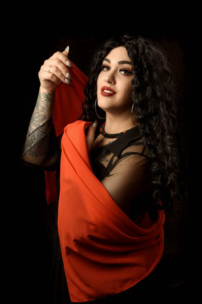 Girl gypsy fortune teller with a tattoo in a black dress with a red handkerchief