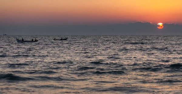 Barcos de pesca em ondas e pôr do sol . — Fotografia de Stock