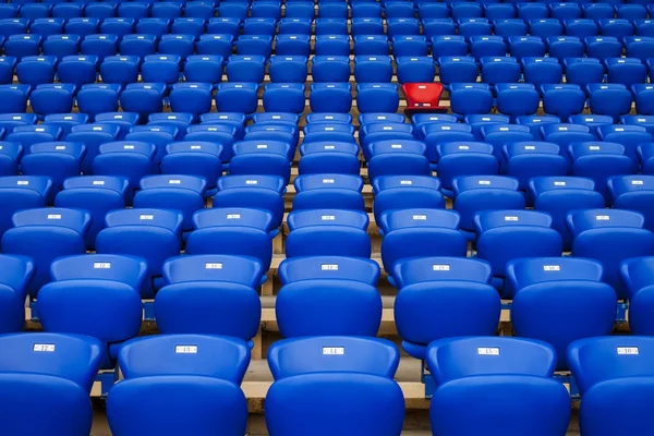 Sillón rojo en una fila de sillones azules. Sé diferente. Ser especia —  Fotos de Stock