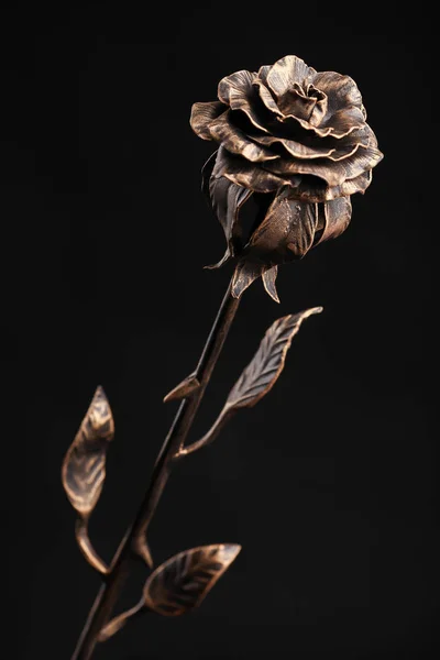 Роза з металу бронзового кольору на чорному тлі — стокове фото