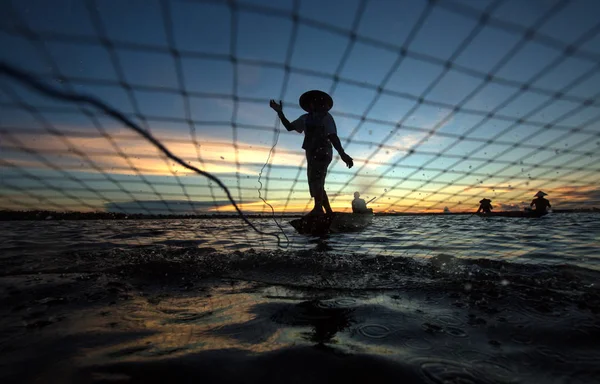 Silhouette pêcheur sont filet de pêche — Photo