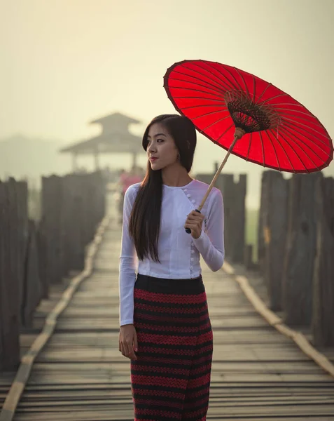 Myanmar mujer en vestido tradicional caminando sobre el puente u bein —  Fotos de Stock