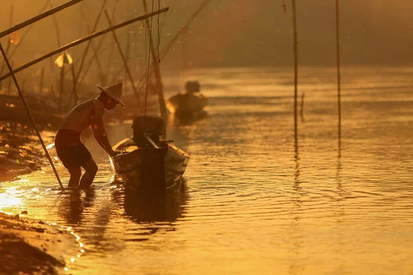 Pescador silhueta com um barco no rio mekong — Fotografia de Stock