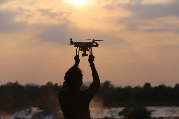 Muž, který držel dron silueta sunset — Stock fotografie
