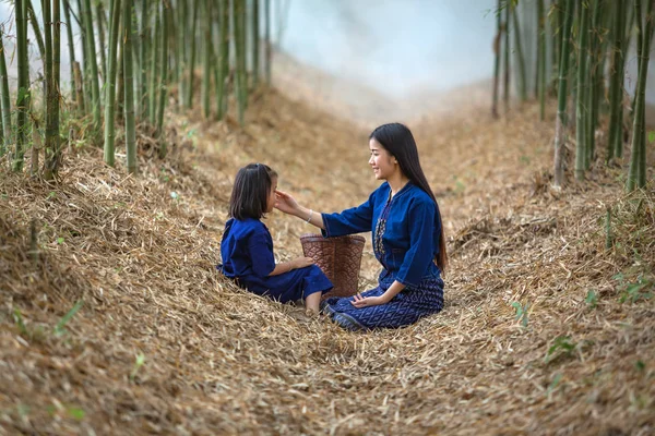Syster är i vården av systrar trädgården planterade bambu. — Stockfoto