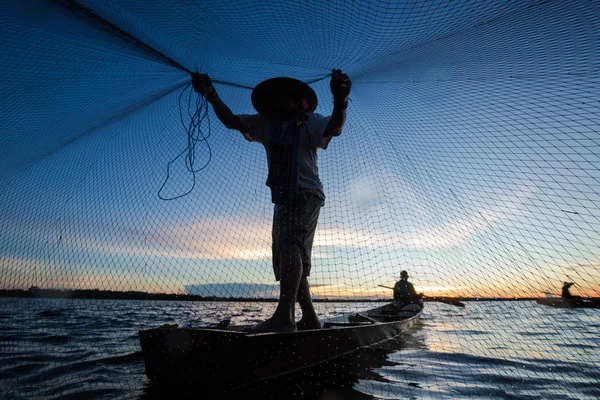 Thailändska Fiskarbyxor på träbåt gjutning ett nät för att fånga färsk — Stockfoto