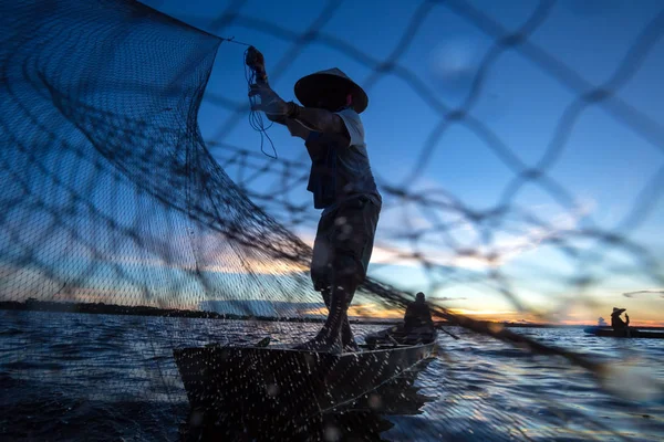 Pescador tailandês em barco de madeira lançando uma rede para pegar fresco — Fotografia de Stock