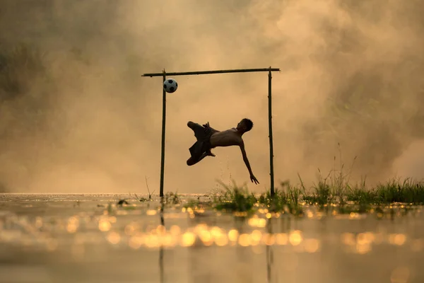 Action shot soccer silhouette garçon saut kick footbal — Photo