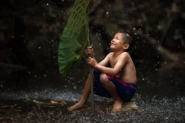 Thai child cheerful with playing water splash in the waterfall — Stock Photo, Image