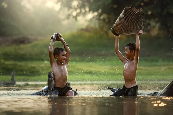 Asia Two boys joyful catch fish in the lake — Stock Photo, Image