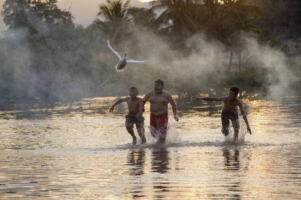 As crianças correm ao longo do rio pato branco — Fotografia de Stock