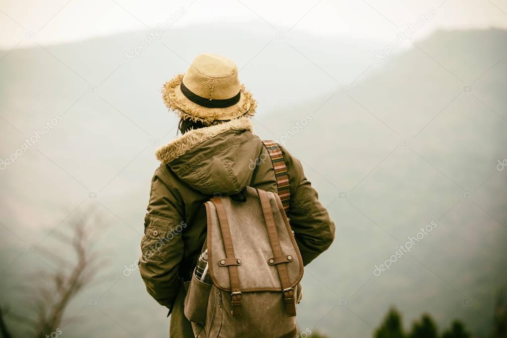 Young Hipster woman traveling in mountain with backpack enjoying