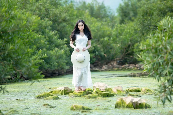 Gyönyörű fiatal hölgy visel fehér ruhában állt a kő v — Stock Fotó
