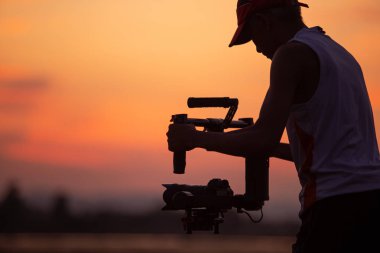The black silhouette of a video photographer was filmed