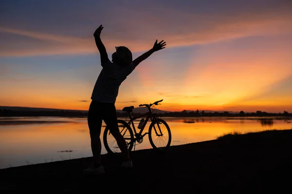 Felicidad silueta ciclista alegre con bicicleta y puesta de sol — Foto de Stock