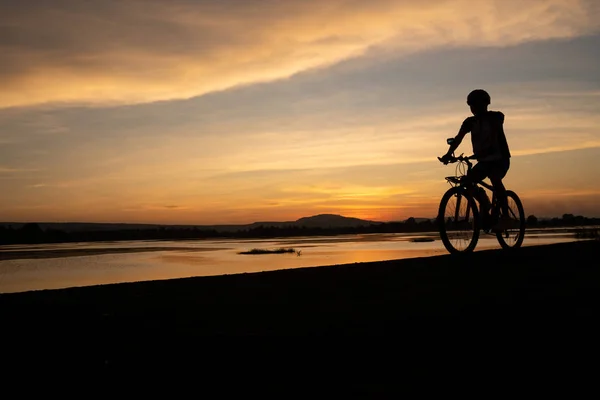 Los hombres asiáticos ciclismo bicicleta en el camino en el tiempo de puesta del sol — Foto de Stock