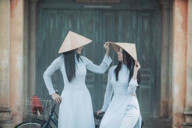 İki güzel kadın Ao Dai Vietnamlıların geleneksel elbisesini giyiyor. 