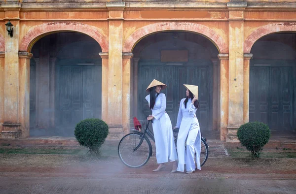 Deux femmes portant la robe traditionnelle Ao Dai Vietnam restent en t — Photo