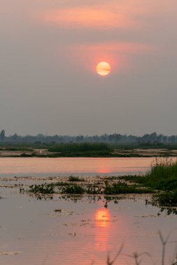 Kırsal kesimin göl kenarı doğasında gün batımı yansıması