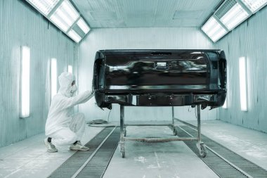 Adam, garajın rengini boyayan bir renk teknisyeni. 