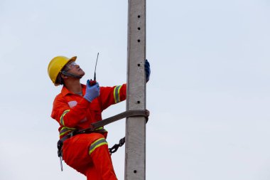 Elektrikçiler yüksek voltajlı elektrik direklerinin yanı sıra güvenlik ekipmanları ve radyo iletişimi üzerinde çalışıyorlar..