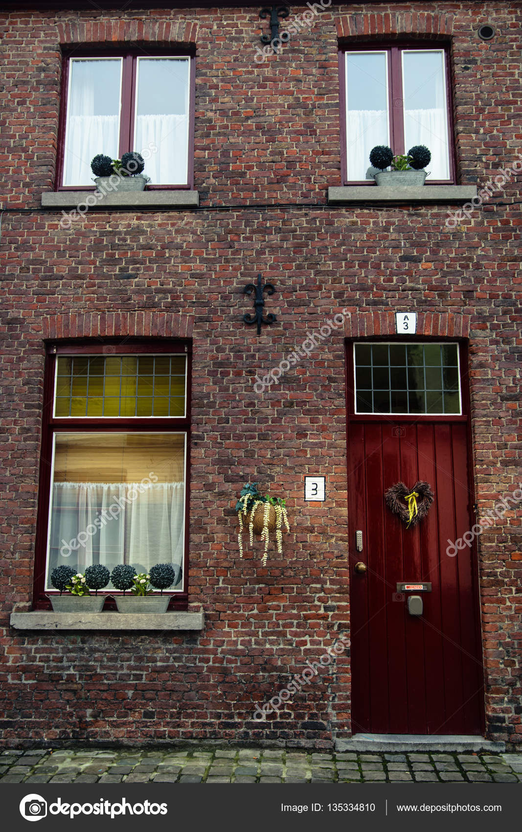 Drie rode houten ramen met witte gordijnen en deur met hartvormige ... Drie rode houten ramen met witte gordijnen en deur met hartvormige ...
