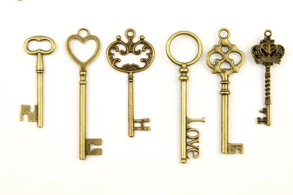 Декоративні середньовічні вінтажні ключі зі складною куванням, що складаються з елементів бліх-де-лісів, вікторіанських листових суглобів і серцеподібних скель. антикварний золотий ключ дверей ізольований на білому тлі — стокове фото