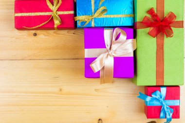 Ahşap arka plan tebrik kartı tatil kavramı mevcut kutulara. Ahşap masa üzerinde Noel renkli hediye kutuları. Kopya alanı ile Üstten Görünüm