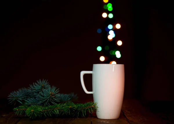 Weißer Kaffeebecher und Weihnachtsbeleuchtung — Stockfoto