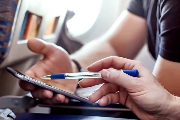Мужчина и женщина с помощью современного телефона в самолете крупным планом — стоковое фото