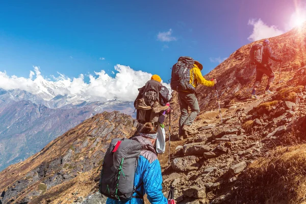 Grupo de pessoas caminhando na trilha da montanha com o sol — Fotografia de Stock