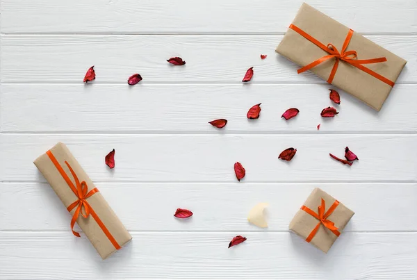 Sevgililer günü kavramı hediye kutuları Beyaz ahşap çiçek yaprakları dekore edilmiştir. — Stok fotoğraf
