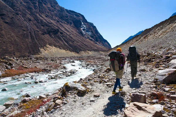 Människor som vandrar längs Creek med ryggsäckar — Stockfoto
