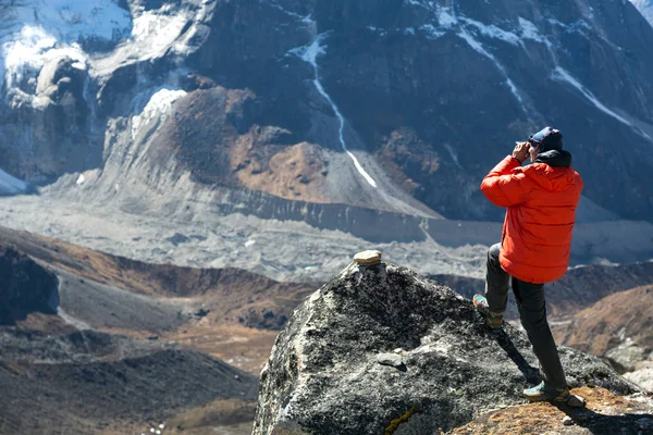 Bergbeklimmer nemen foto van dalen — Stockfoto
