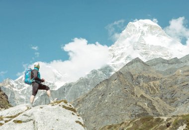 Kayanın üzerinde kalan sırt çantası olan adam