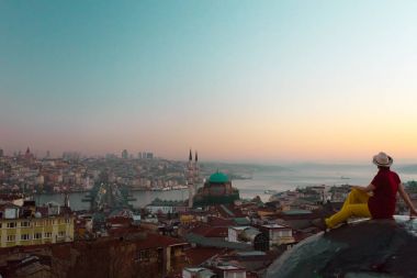 Çatıda oturan şapkalı Bayan