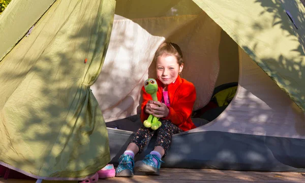 Menina sentada na tenda de acampamento — Fotografia de Stock