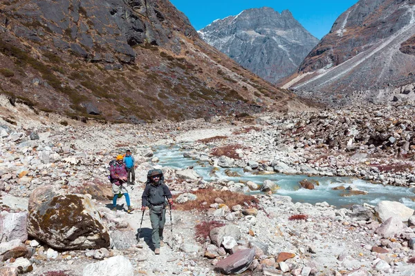 Туристи, гуляючи по диких гірській річці — стокове фото