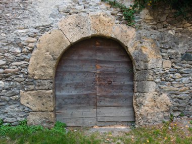 Bir Ortaçağ taş duvar antik kemerli kapıdan 