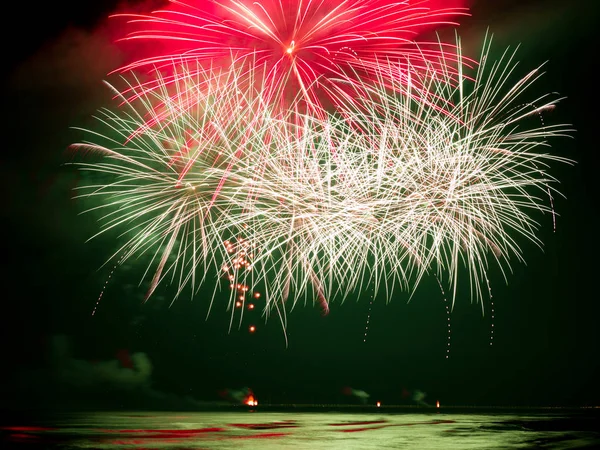Fireworks  explosion reflecting in the water of the sea — Stock Photo, Image