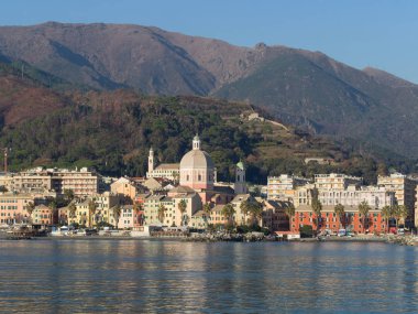 Pegli, Genoa, mahalle deniz, renkli dar evleri, avuç içi ve büyük kilise Akdeniz'de yansıtan her bakıldığında. Dağlar, tepeler ve mavi gökyüzü arka planda 