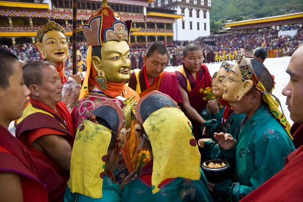 Enmascarado figura siendo llevado más allá de multitud en Bután — Foto de Stock