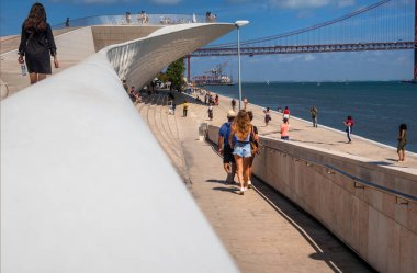 Sanat, Mimarlık ve Teknoloji Müzesi 'nin arka planında Tagus Nehri, Belem, Lizbon, Portekiz' i kapsayan 25 Nisan Köprüsü bulunuyor.