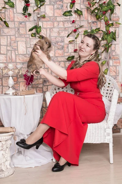 Ugly domineering woman is posing in red dress